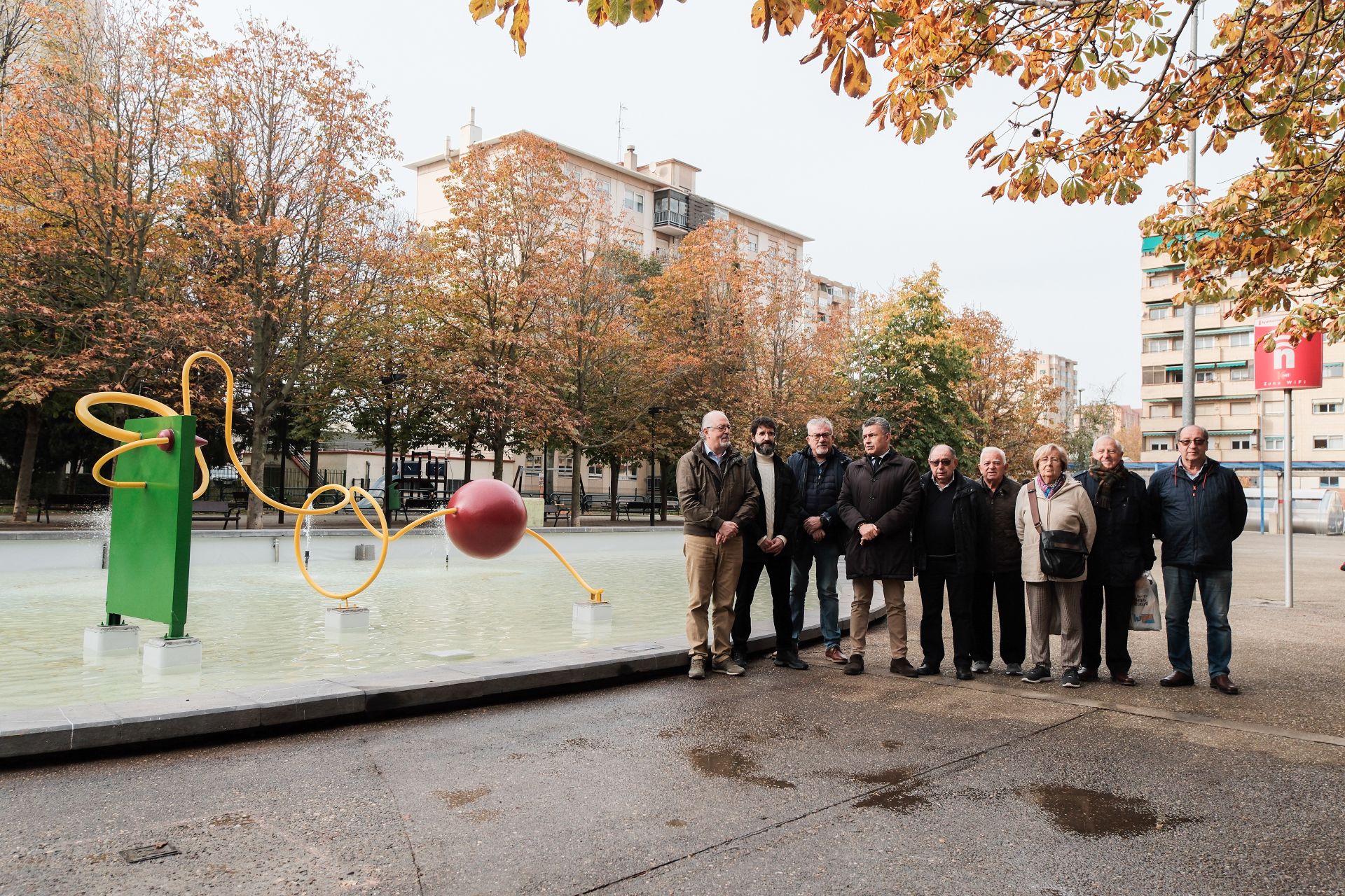 Vecinos y autoridades, este martes, durante la puesta de largo de la remodelada fuente, con el autor de la escultura recolocada.