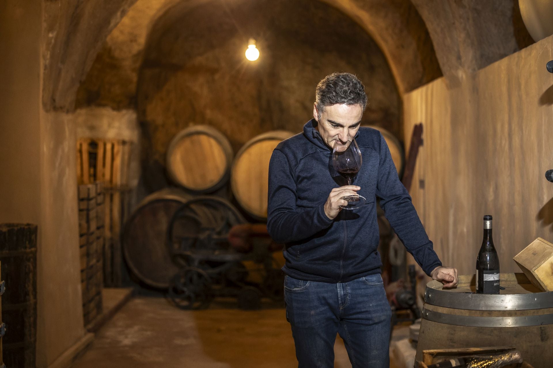 Arizcuren cata su vino en su cueva del barrio de bodegas.