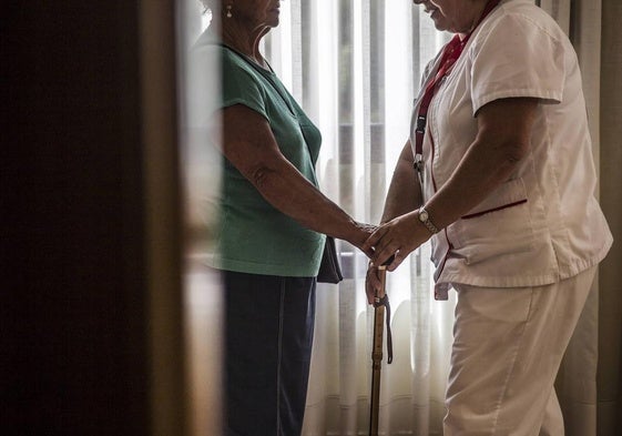 Una auxiliar atiende a una usuaria de una residencia, en una imagen de archivo.