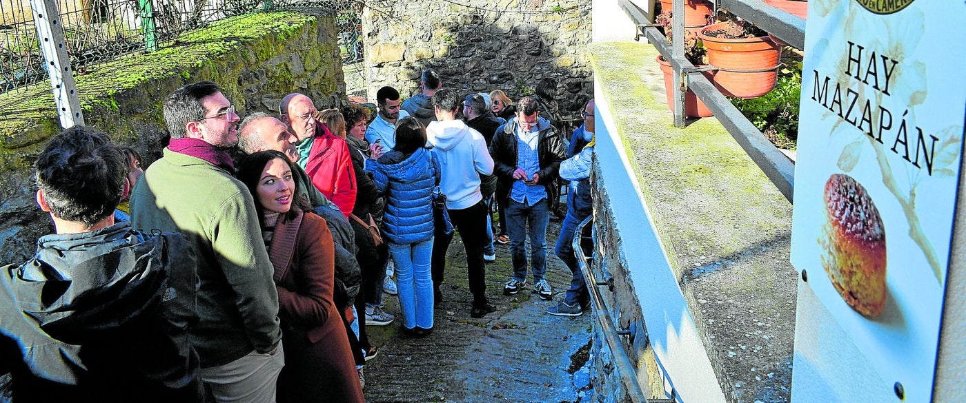 Un grupo de personas espera a la entrada para iniciar su visita al obrador de la fábrica Viuda de Manuel Redondo, única fábrica de mazapanes que queda en Soto en Cameros.