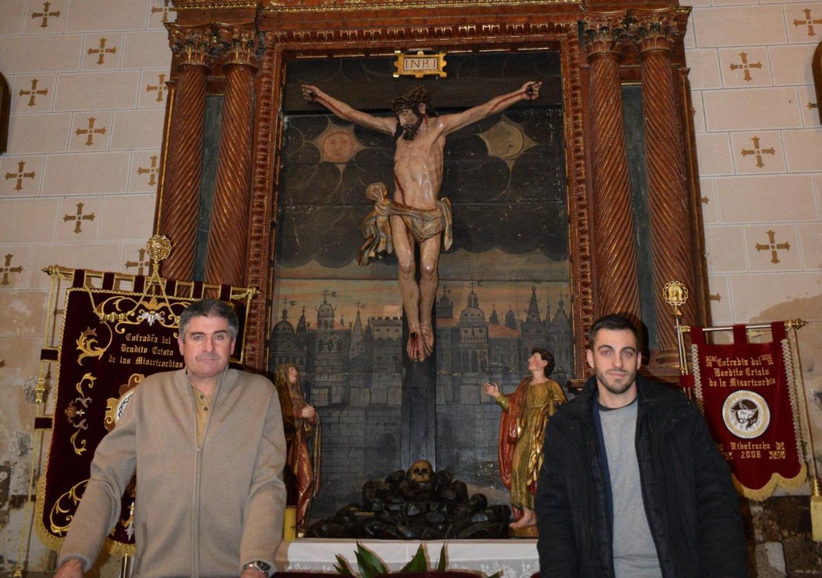 Pedro Sáenz y Óscar González posan ante el retablo a restaurar.