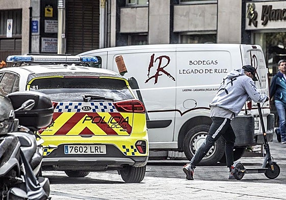 Un usuario de patinete eléctrico se cruza con un vehículo de la Policía Local de Logroño en una imagen de archivo.