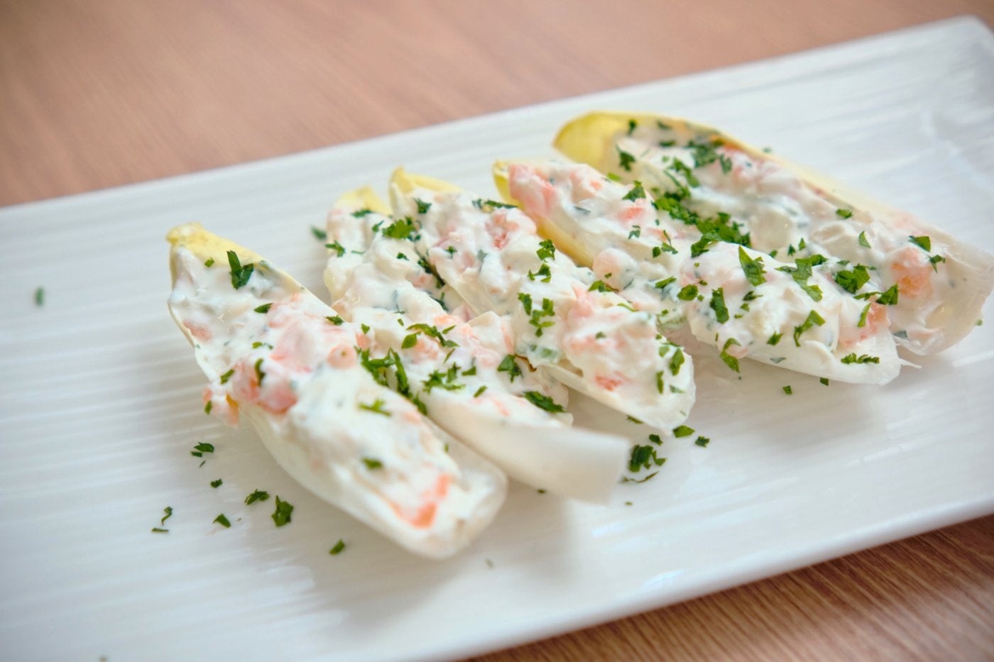 Una fuente con endivias con gorgonzola, pera y salmón.