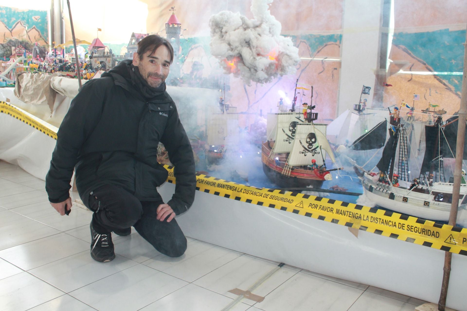 Nalda posa sonriente en la parte que retrata la época pirata, con barcos de vela y batallas navales.