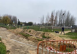 Un usuario del centro de esparcimiento canino que desaparecerá trata de acceder a la entrada entre zanjas y vallas.