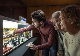 David, Martín y Mari Cruz, junto a la maqueta en miniatura del bar 5 Pesos, el regalo que el hijo les hizo a sus padres por su jubilación.