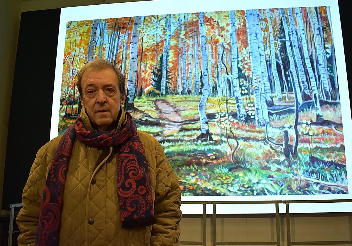 Félix Ángel Gurrea junto a la pantalla del Museo del Vino junto a una de sus obras proyectada.