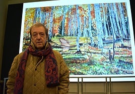 Félix Ángel Gurrea junto a la pantalla del Museo del Vino junto a una de sus obras proyectada.