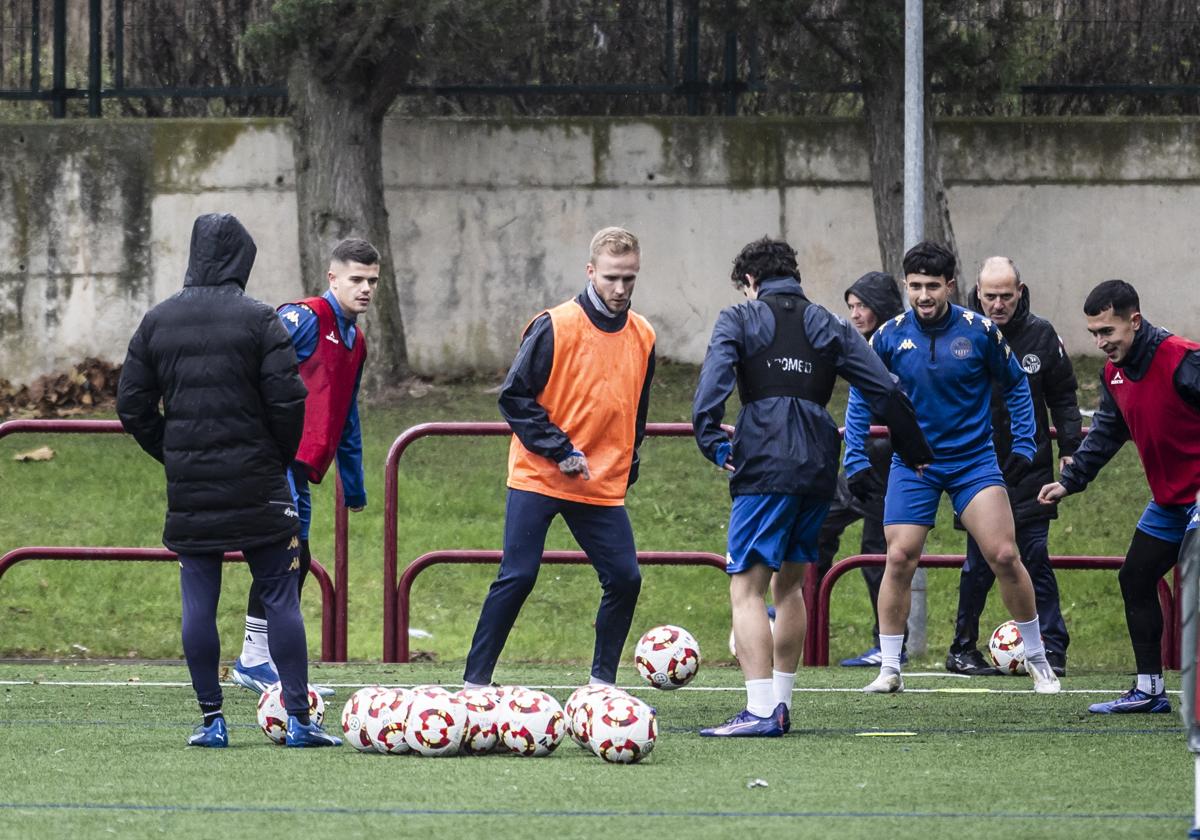 Los jugadores de la SDLogroñés realizan un rondo con Sergio Gil en medio.