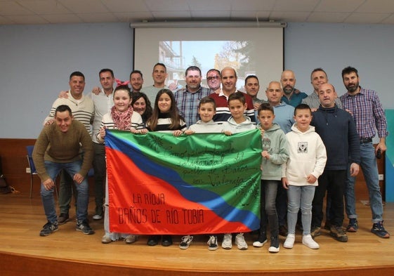 Los voluntarios bañejos que fueron a Valencia posan con la bandera que regalaron a la asociación AOFS.