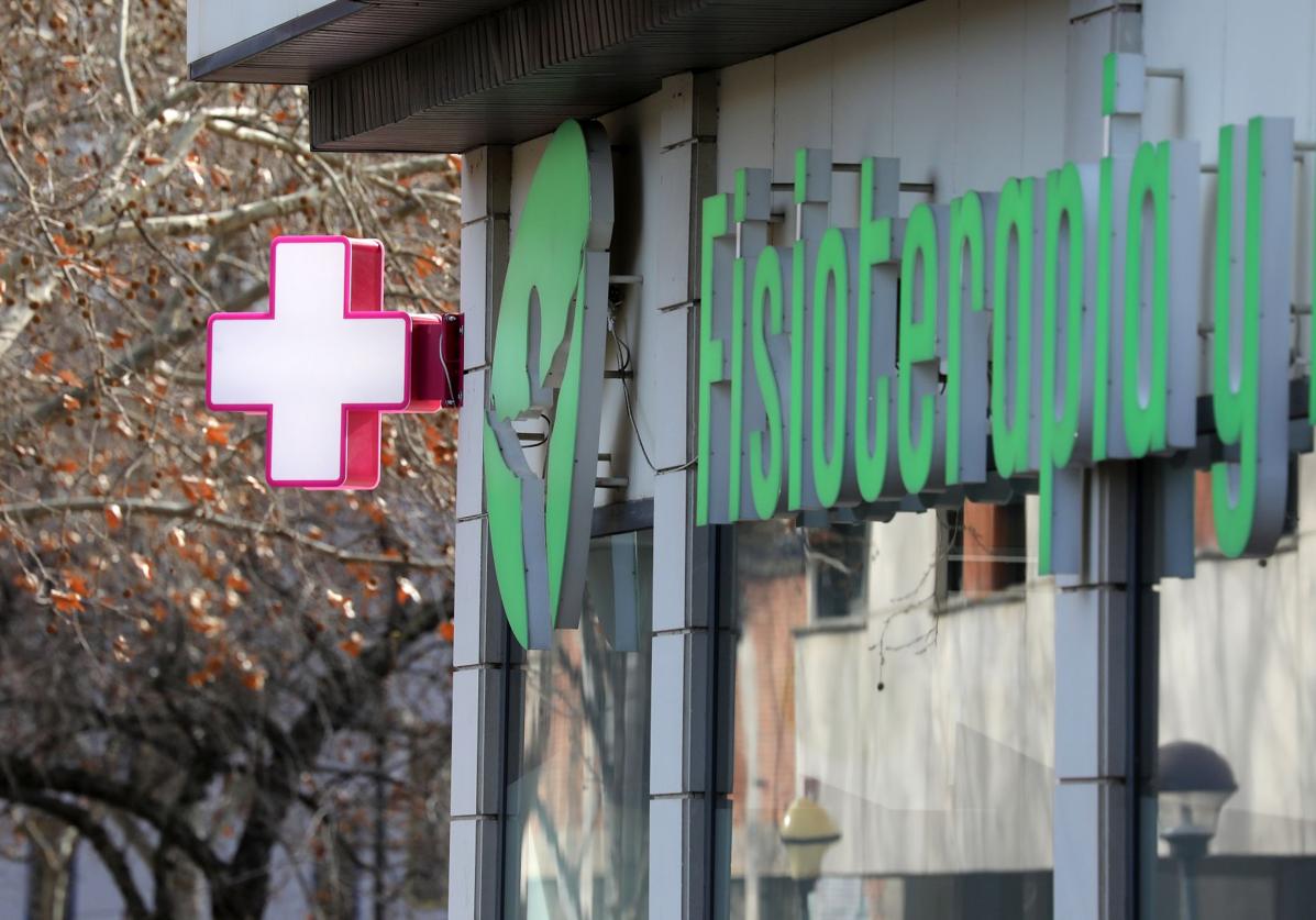 Cruz blanca y fucsia instalada en un centro de fisioterapia de Logroño.