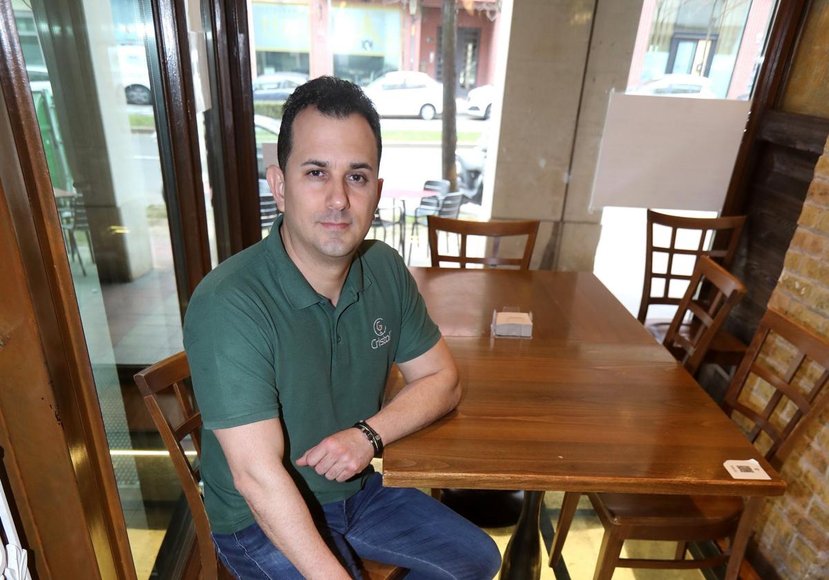 Rafael Álvarez, sentado sobre una de las cristaleras decorativas del suelo; encima, interior del bar Cristal.