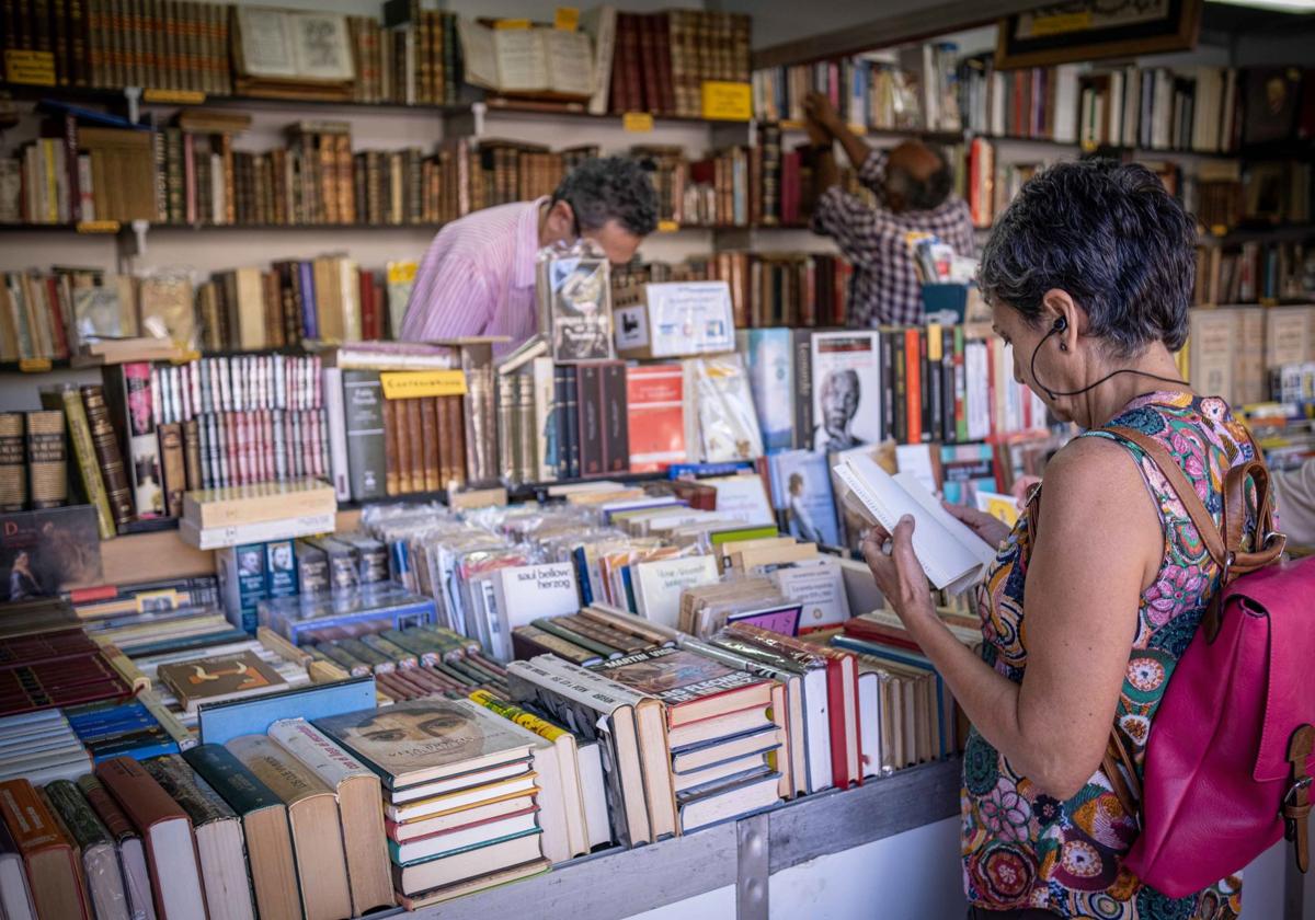 Una mujer consulta un ejemplar en la feria del libro de Logroño.