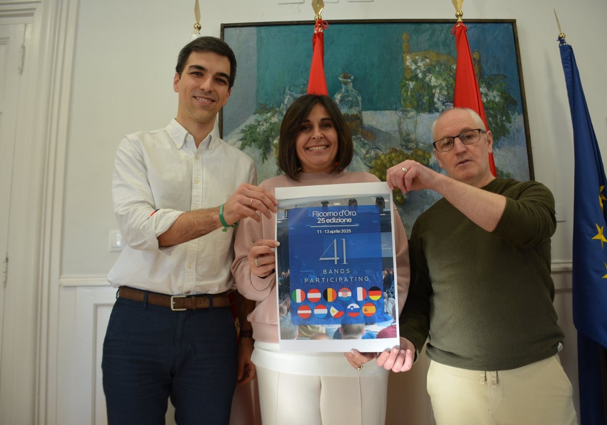 Álvaro Ridruejo, presidente de la Asociación Banda de Música de Calahorra; la concejala de Cultura, Reyes Zapata y el director de la banda, Eduardo Peña, con el cartel del concurso. I. Á.