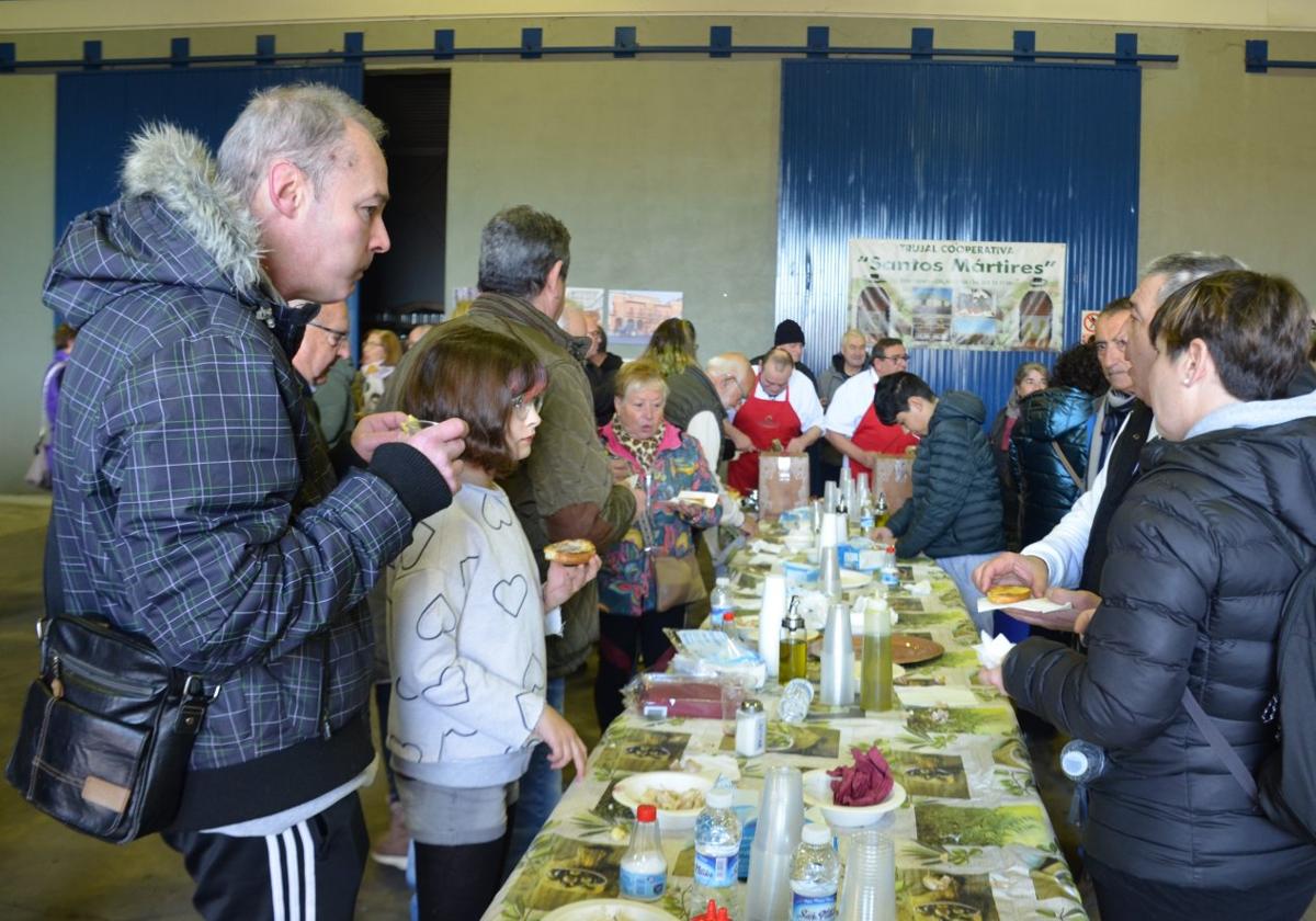 Público degustando las tostadas con aceite y jamón.