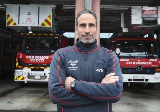 Daniel León, delante de dos camiones en el Parque de Bomberos de Logroño.