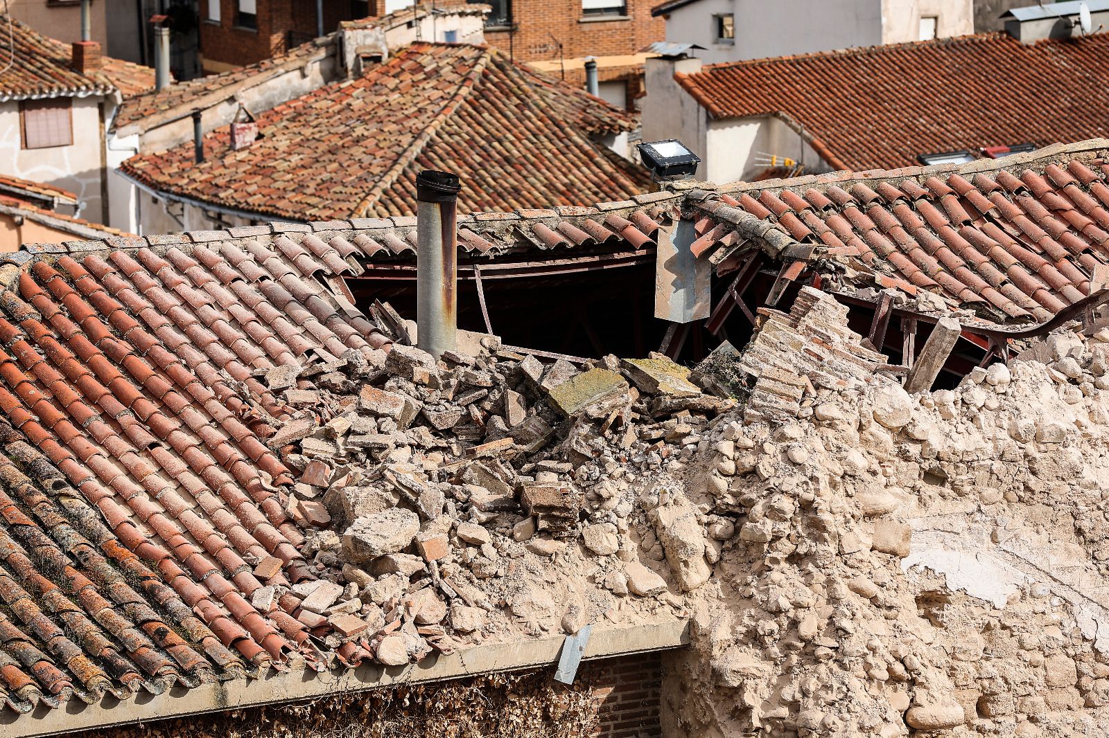 Detalle del agujero que ha provocado en el tejado de la iglesia el derrumbe de la torre.