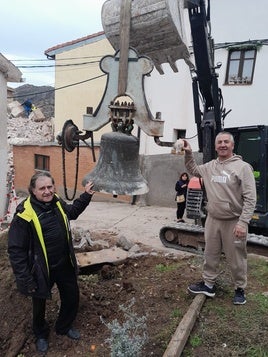 El párroco Fernando García y el vecino de Viguera José Félix González posan con la campana recuperada.
