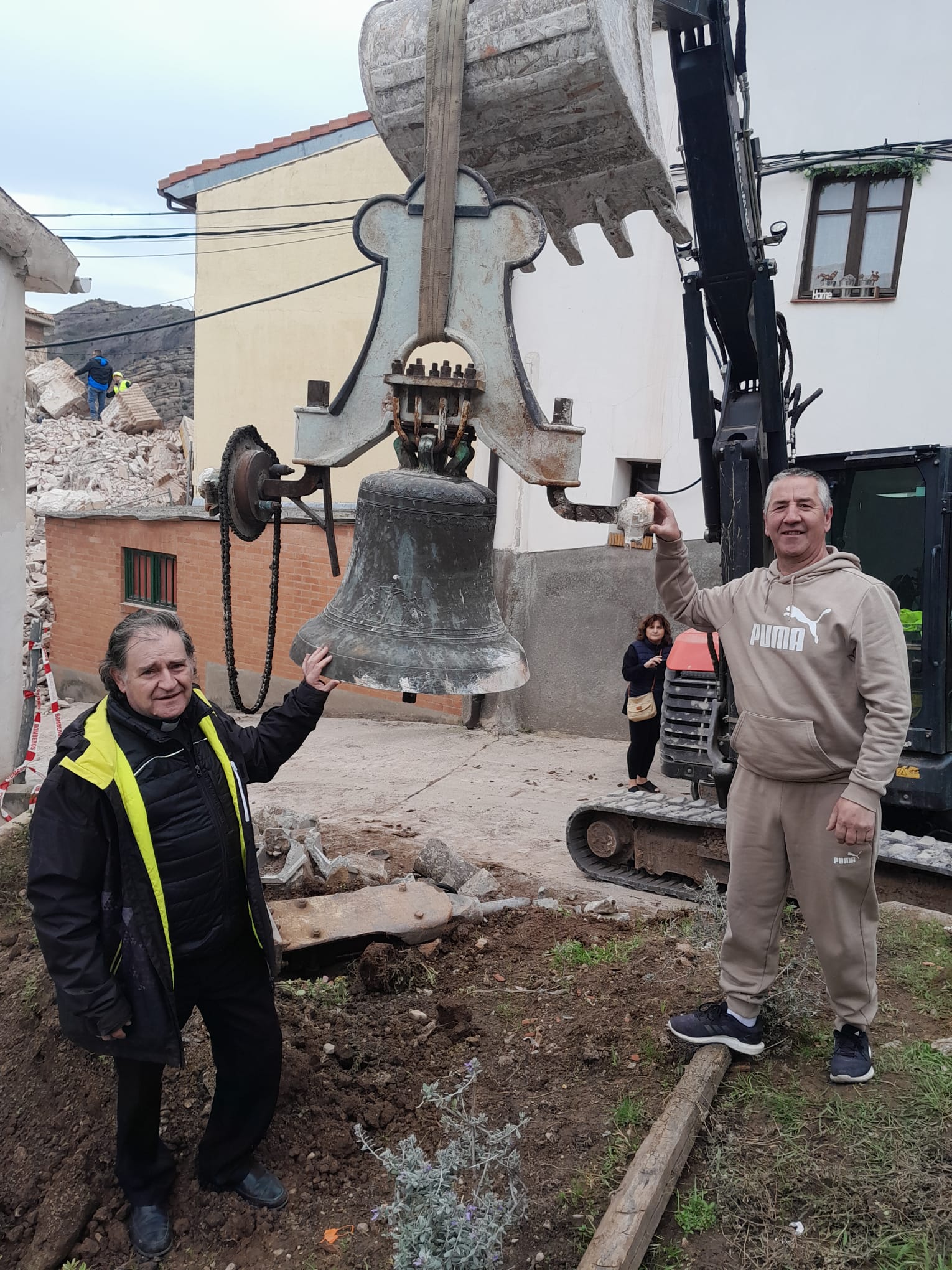 El párroco Fernando García y el vecino de Viguera José Félix González posan con la campana recuperada.
