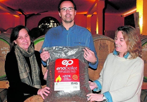 Los responsables de la alcoholera posan con uno de los sacos de quince kilos de enopellet, dentro de la bodega de la empresa.
