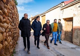 Varios políticos, con el alcalde en el centro, pasean por el pueblo.