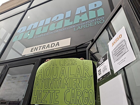 Un miembro de la plantilla de Ocio Sport en el Aqualar de Lardero muestra un cartel de protesta.