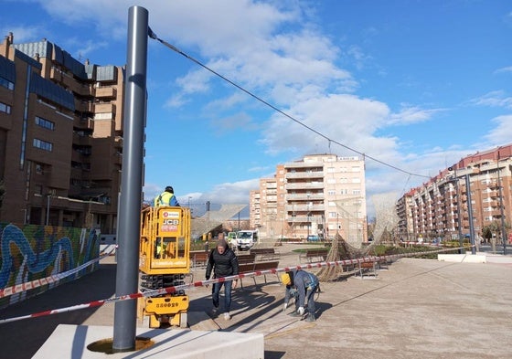 Operarios de Asbeca en plena retirada de la red de tensores que sostenían las luminarias y la malla de sombra.