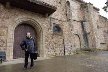El párroco de Viguera, Fernando García, posa en la puerta de la iglesia de la Asunción.