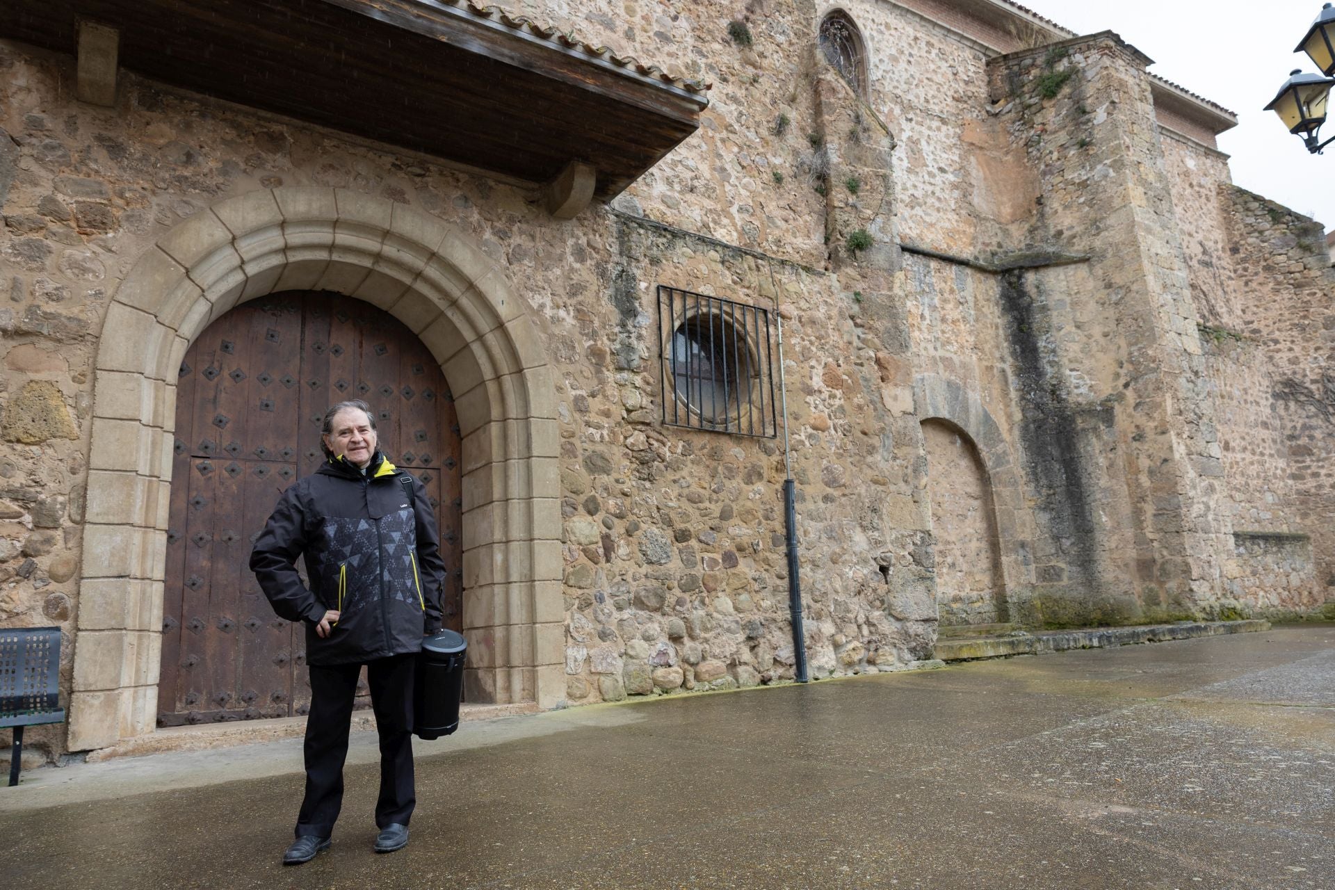 El párroco Fernando García, posa ante la iglesia de Viguera.