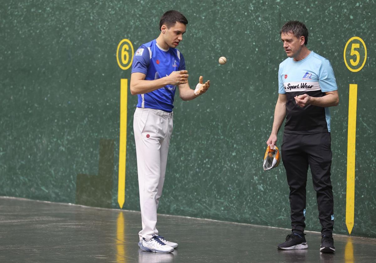 Zabala examina una pelota junto a Etxaniz.