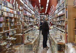 Un hombre observa los ejemplares de una librería.