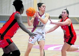 Elena Salcedo intenta desprenderse de dos jugadoras de León.