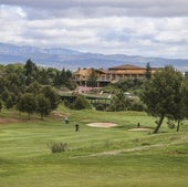 Varios jugadores avanzan por la calle de uno de los hoyos, en una vista panorámica del campo y la Casa Club.