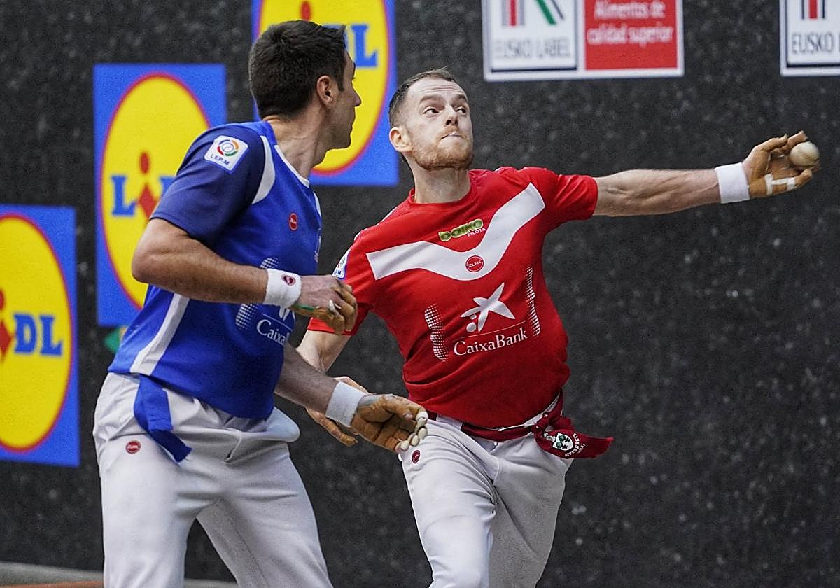 Unai laso golpea la pelota con la izquierda ante la mirada de Peio Etxeberria, en su enfrentamiento en el Manomanista.