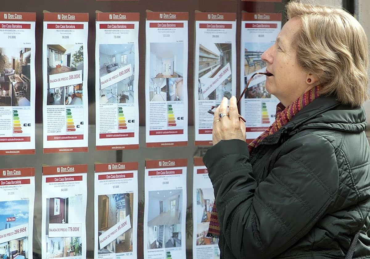 Una mujer observa los anuncios sobre alquileres en una inmobiliaria.