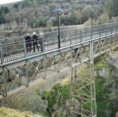 Tres vecinas de Ortigosa cruzan el puente de hierro.