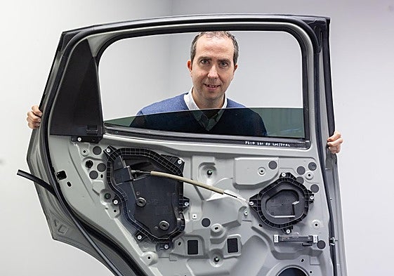 Daniel Rueda sujeta una puerta de coche con numerosos componentes fabricados por las industrias auxiliares riojanas.