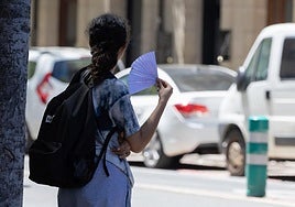 Una mujer se abanica debido al calor.