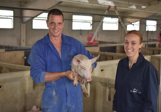 Isidro y Verónica en su granja de la Careta de Valverde con un lechón.