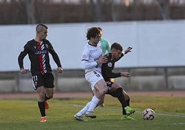 Barrero protege el balón ante la presión de Aitor Pérez.