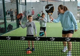 Carolina Navarro indica a un pequeño cómo ejecutar mejor su golpe.