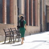Una mujer se tapa con el abanico para protegerse del sol.