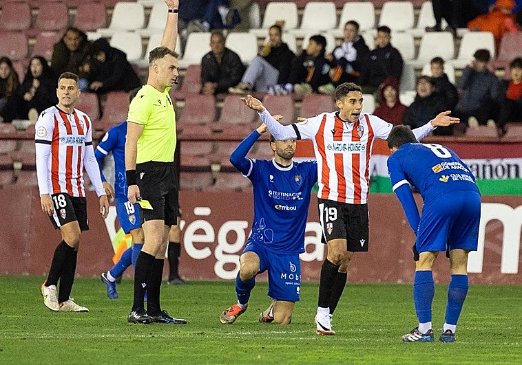 Miguel Marí, de rodillas en el césped, protesta una decisión colegial.