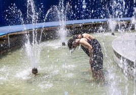 Dos jóvenes tratan de refrescarse en una instalación de Concéntrico.