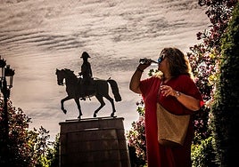 Una mujer se refresca con un botellín de agua en El Espolón.