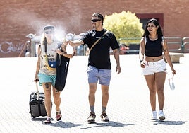 Unos jóvenes se refrescan con agua en el entorno de Las Norias.