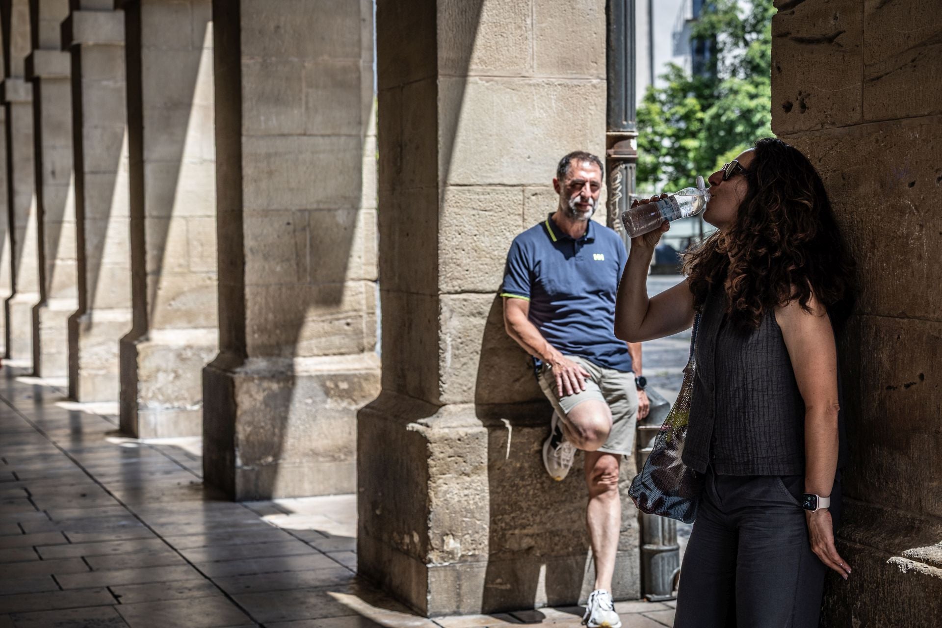 Dos paseantes, en los portalillos de la Plaza del Mercado durante la última ola de calor