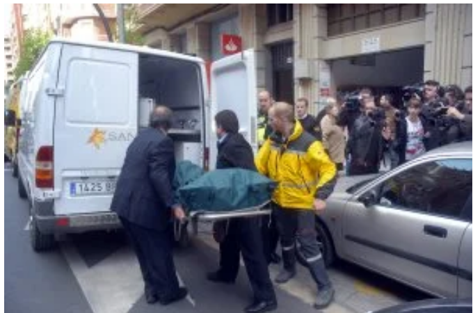 El cuerpo de la mujer, que murió a manos de su hermano, cuando era introducido el en el furgón funerario.
