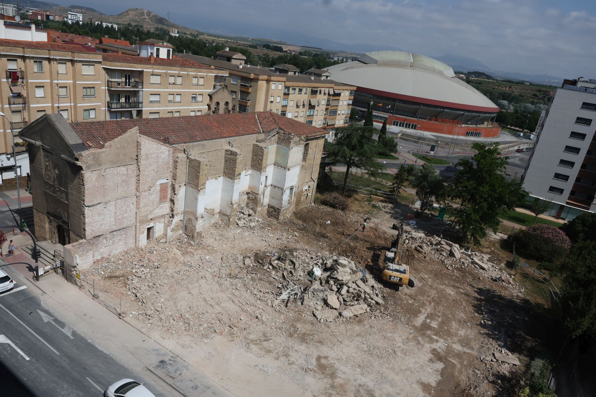 Solar resultante tras el derribo del convento junto a la iglesia, con una excavadora retirando los últimos escombros.