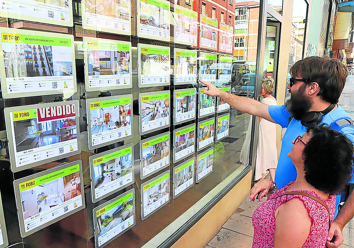 Clientes en los carteles de una inmobiliaria.